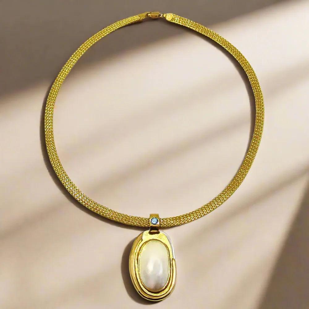 Necklace with a 18k gold medallion mother of pearl and a bleu topaz in a hand made 14k. gold chain