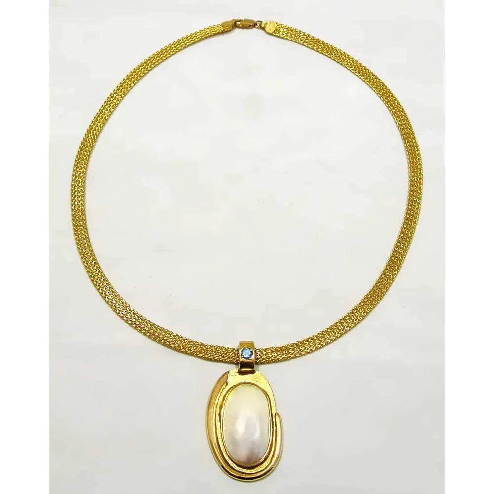 Necklace with a 18k gold medallion mother of pearl and a bleu topaz in a hand made 14k. gold chain