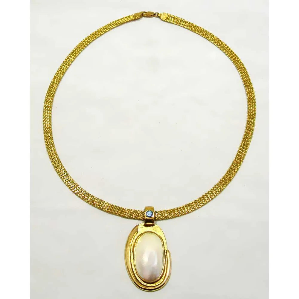 Necklace with a 18k gold medallion mother of pearl and a bleu topaz in a hand made 14k. gold chain
