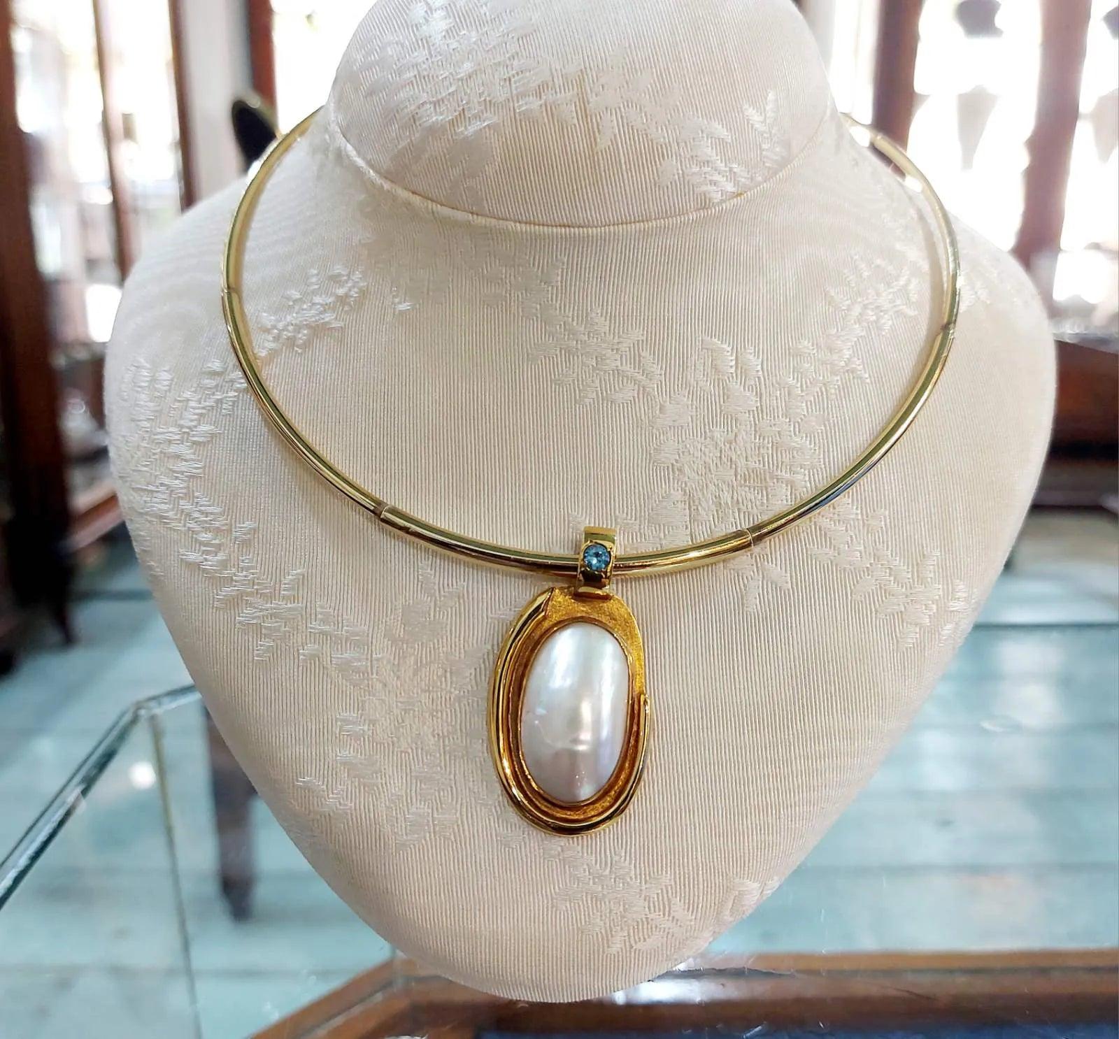 Necklace with a 18k gold medallion mother of pearl and a bleu topaz in a hand made 14k. gold chain