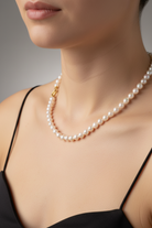 Pearl necklace worn by a model against a neutral background